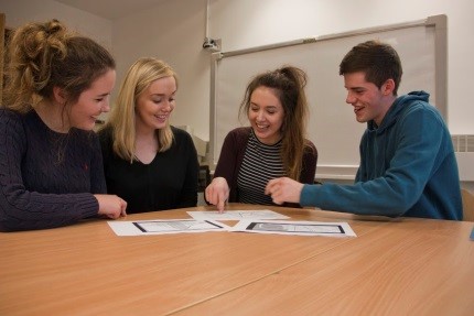 Student sitting around a table discussing some charts 2016